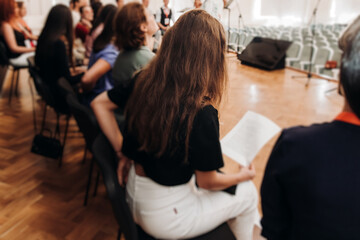 Choir rehearsal, vocal class singing in the auditorium hall, group of students on stage holding...