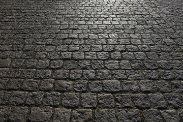 Stone road background texture. Textured background of cobblestone road. Road from brick background. Paving stone and paved road. Sidewalk background.