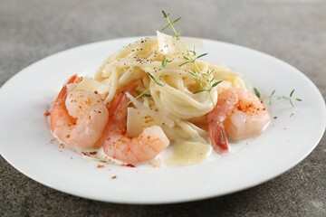 Delicious pasta with shrimps and cheese on grey table, closeup
