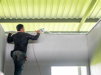 Technician pull wires through conduit.