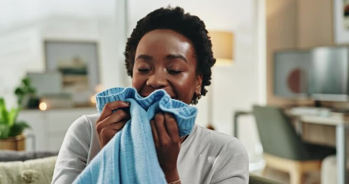 Black woman, smell and clothes for aroma at house with washing laundry, spring cleaning and detergent scent. Smile, female person and soft fabric for hospitality, textile care or housekeeping service