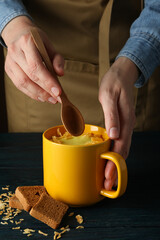 Cheese soup in a yellow cup on a wooden table