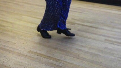 Bottom view of tap dancing backwards across a wooden floor