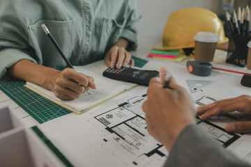 an architect and his assistant are brainstorming and examining the blueprints, two engineers are discussing a construction plan to make the structure stronger, draft, meeting, teamwork