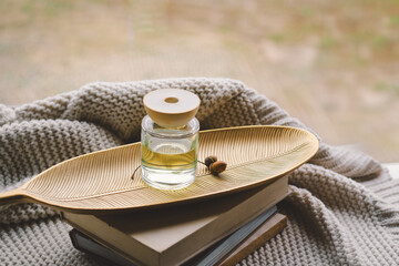 Cozy indoor setting with a Incense sticks for the home with a floral scent surrounded by a cozy knitted blanket and scattered leaves, creating a serene atmosphere in a relaxed indoor space.