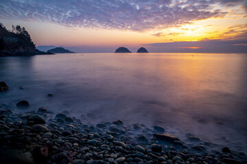 Long exposure photography of waves and pebbles on Musulmok Beach in the morning at Yeosu-si, South Korea 