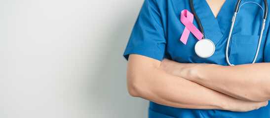 Pink October Breast Cancer Awareness month, woman doctor with pink Ribbon in hospital for support people life and illness. National cancer survivors month, Mother and World cancer day concept