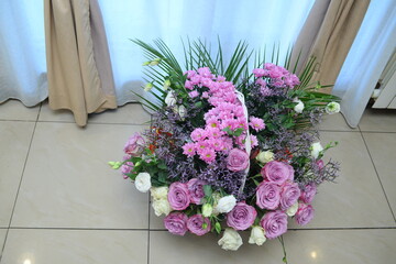A bouquet of purple and white flowers in a white basket