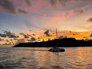 Serene Sunset Sailing with a Vibrant Tropical Sky and Peaceful Ocean Views