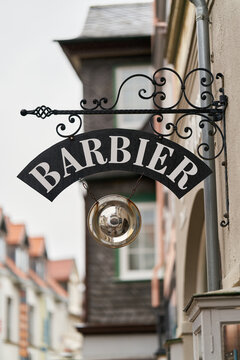Zunftzeichen und Hinweisschild mit der deutschen Aufschrift Barbier