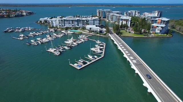 Driving Across Ephraim Island Bridge From The Mainland At Paradise Point Parklands In Queensland, Australia. Aerial Drone Shot