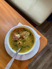 Red Snapper fish spicy soup Sour curry in a white bowl with garlic, tomatoes, vegetable and chili...
