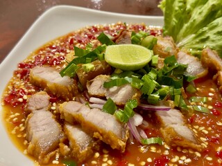 Spicy Pork Salad Delight: A tantalizing Thai dish of crispy pork belly, fiery chilies, and zesty lime, ready to tantalize your taste buds.