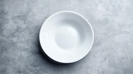A single white plate on a grey background.