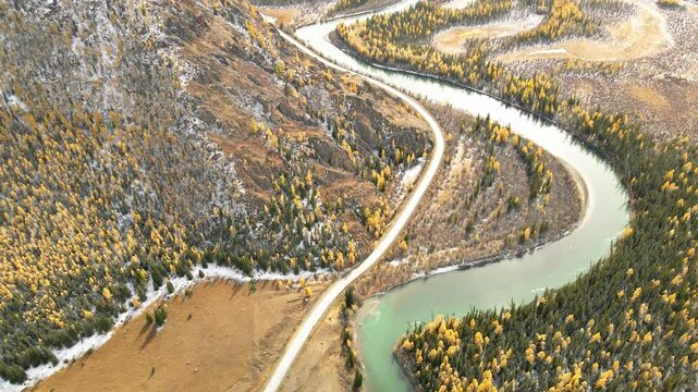 Chuya river and Chuysky tract road in Altai mountains, Siberia, Russia. Aerial view. River with yellow autumn trees in the mountains. Beautiful autumn landscape. 
