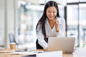 Business Asian woman freelancer is working her job on a laptop computer and phone call in the office. Doing accounting analysis report real estate investment data, Financial and tax systems concept.	