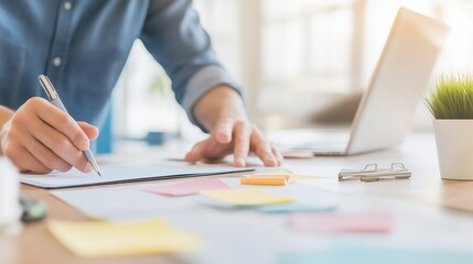 Fototapeta premium Focused workspace scene showing a person writing on paper, emphasizing productivity and organization.