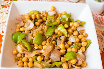 Fresh and nutritious chickpea and capsicum salad served in a white plate. Light and healthy lunch or dinner option, packed with plant-based protein and fiber, supports weight loss and fitness goals
