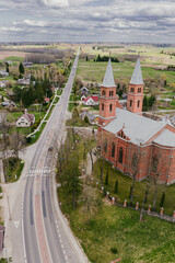 road and a church in a small European town in spring aerial photo