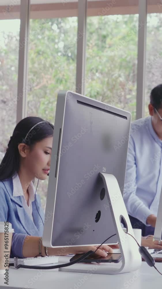 Poster customer support agent or call center with headset works on desktop computer while supporting the cu