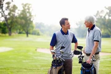 Father, son and happy on course for golf, talking and bonding outdoor with equipment bag or conversation. Elderly person, man and smile on grass for hobby, sports and playing game at country club