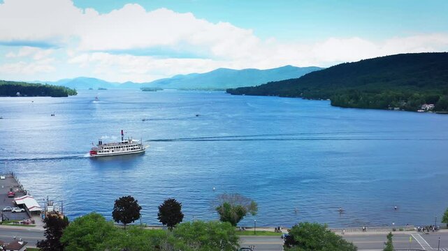 Drone shot of a steamboat and speed boat sailing towards each other on Lake George in upstate New York