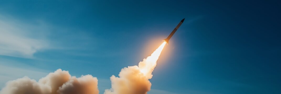 A rocket launches upward with a bright plume of smoke and fire, set against a clear blue sky background.