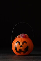 Trick or treat. Pumpkin Jack filled with various creepy sweets on black background