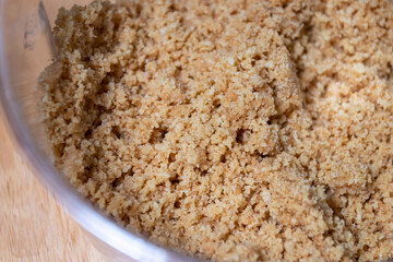 A close-up of finely ground brown sugar, highlighting its texture and color, perfect for culinary uses and baking.
