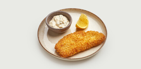 A crispy and golden-brown fish fillet, battered and deep-fried to perfection, is served on a beige plate against a clean white background.