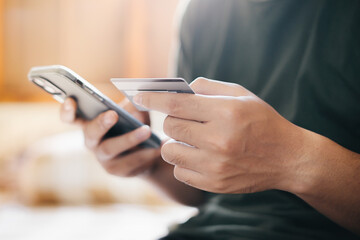 A man holding smartphone and credit card for online electronic transaction payment