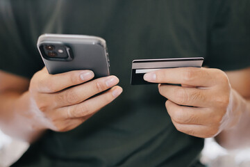 A man holding smartphone and credit card for online electronic transaction payment