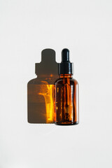 Aromatic Essential Oil Bottle With Dropper on White Surface in Bright Natural Light