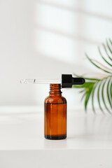 Aromatic Essential Oil Bottle With Dropper on White Surface in Bright Natural Light