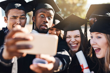 Obraz premium Students, graduation and selfie with friends, happy or funny face with cheers, excited or success at college. People, group and diversity for photography, memory or goal with diploma on social media