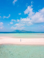 a man stands on a sandbar surrounded by turquoise ocean. summer background and summer holiday.