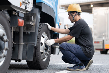 トラックのタイヤを点検する男性