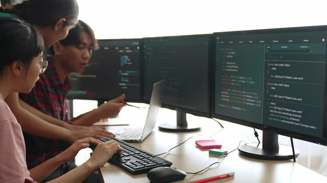 Slow motion back end software developer engineer for computer programming working together on debugging writing computing code, solving complex algorithms display on monitor in office. Burgeoning