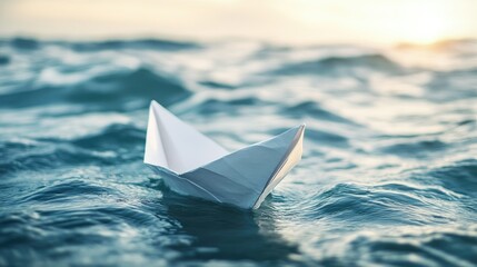 Obraz premium Closeup of a white paper boat drifting on the surface of the sea, surrounded by gentle waves.