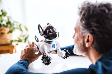 The man is looking at adorable robotic dog.