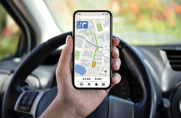 male hands hold phone with navigation application background wheel car