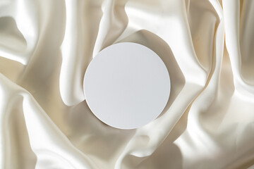 Modern Minimalist White Sculpture Displayed on Soft Draped Fabric in Natural Light