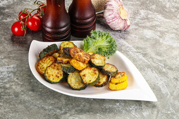 Roasted young zucchini in the plate