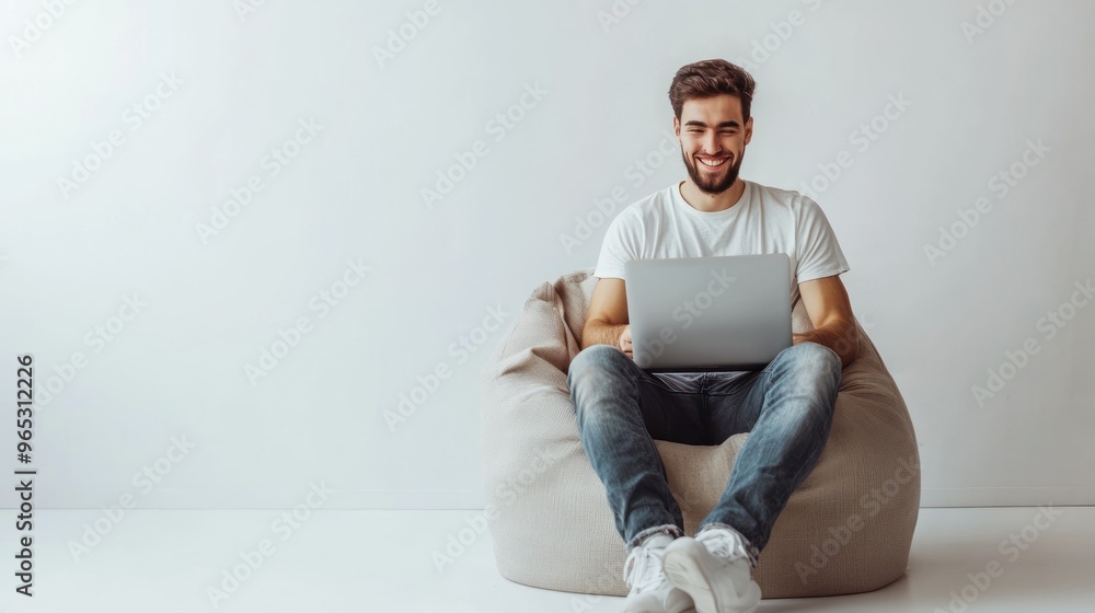 Aufkleber smiling man in a white t-shirt using a laptop while sitting on a beanbag chair