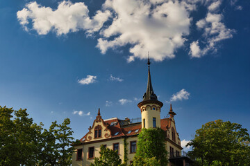 Obraz premium Historische Villa mit markantem Eckturm, Ziergiebeln und Efeubewuchs unter blauem Sommerhimmel, Grimma an der Mulde, Sachsen, Deutschland