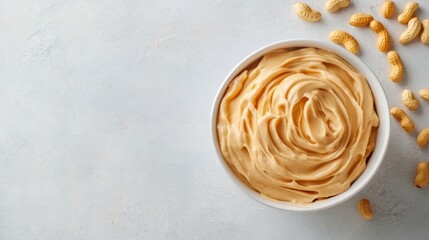 Bowl of peanut butter and peanuts on table background. top view with copy space. Creamy peanut pasta in small bowl.