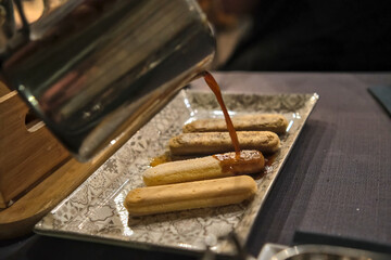 Preparation of homemade tiramisu. Coffee is poured over the cookies.