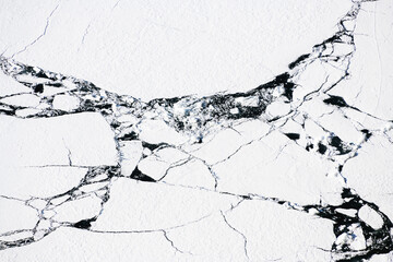 Melting ice on Baikal lake in spring. Abstract nature background. Aerial top down view
