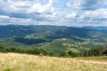 Fototapeta premium Mountains ranges Carpathian. Hill forest and meadows valley in summer. Blue sky