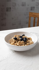 Oatmeal in round white plate on a light marble surface